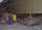 Werknemer tilt een zwaar brugdeel op met behulp van hydrauliek